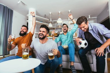 Heyecanlı arkadaşlar maç izleyip, bira içip, mısır patlatıyorlar.