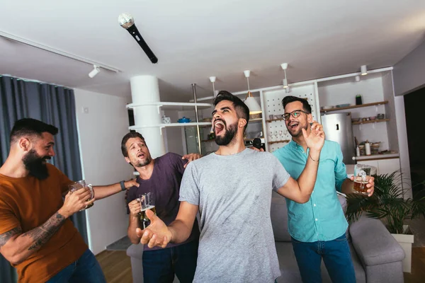 Yakışıklı Genç Adam Mikrofonla Şarkı Söylüyor Modern Dairede Arkadaşlarıyla Karaoke — Stok fotoğraf