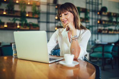 Kafeteryada oturan genç kadın ve online alışveriş yapmak