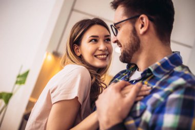 Modern mutfakta genç bir çift, dans ediyor ve gülüyor, mutlu bir eş ve koca favori müziğe taşınıyor..