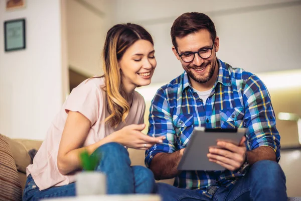 Pareja Joven Está Navegando Por Internet Mientras Está Sentado Sofá —  Fotos de Stock