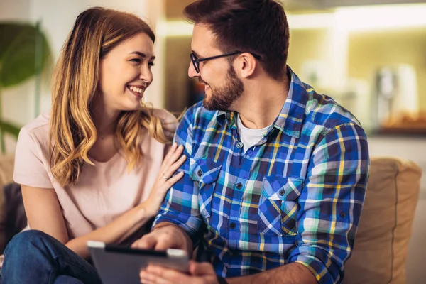 Pareja Joven Está Navegando Por Internet Mientras Está Sentado Sofá —  Fotos de Stock