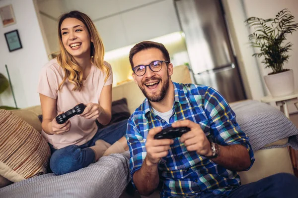 Pareja Joven Sentada Sofá Una Sala Estar Jugando Videojuegos —  Fotos de Stock