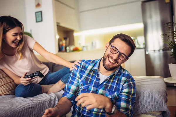 Pareja Joven Sentada Sofá Una Sala Estar Jugando Videojuegos — Foto de Stock