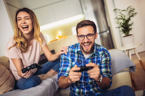 Pareja Joven Sentada Sofá Una Sala Estar Jugando Videojuegos — Foto de Stock