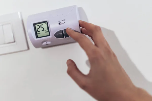 近视一只手调整加热温度 房子墙壁上的数字恒温器 — 图库照片