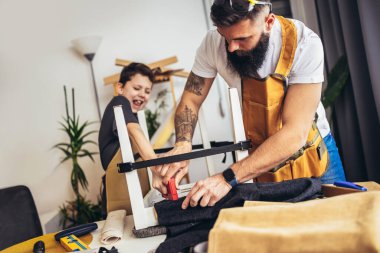 Gülümseyen baba oğluna evde döşemeyi öğretiyor, eğleniyor..