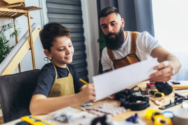 Gülümseyen baba oğluna evde odunla çalışmayı öğretiyor.. 