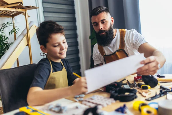 Gülümseyen baba oğluna evde odunla çalışmayı öğretiyor.. 