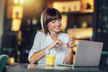 Bir kahve molası verdikten bir dizüstü bilgisayar ile Cafe'de güzel çekici kadın