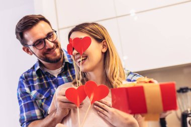 Evde romantik bir çift var. Adam kız arkadaşına hediye veriyor.