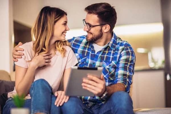 Pareja Joven Está Navegando Por Internet Mientras Está Sentado Sofá —  Fotos de Stock