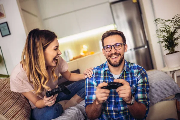 Pareja Joven Sentada Sofá Una Sala Estar Jugando Videojuegos — Foto de Stock