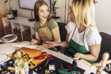 Anne ve kız aksesuar tasarımcıları stüdyo atölyesinde el yapımı mücevherler yapıyorlar. Moda, yaratıcılık ve el yapımı konsept.
