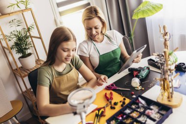 Anne ve kız aksesuar tasarımcıları stüdyo atölyesinde el yapımı mücevherler yapıyorlar. Moda, yaratıcılık ve el yapımı konsept.