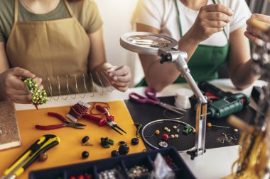 Anne ve kız aksesuar tasarımcıları stüdyo atölyesinde el yapımı mücevherler yapıyorlar. Moda, yaratıcılık ve el yapımı konsept.