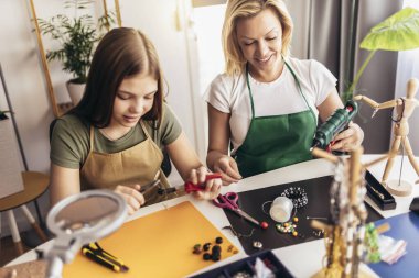 Anne ve kız aksesuar tasarımcıları stüdyo atölyesinde el yapımı mücevherler yapıyorlar. Moda, yaratıcılık ve el yapımı konsept.