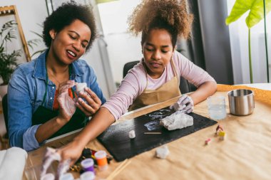 Anne ve kızı birlikte zaman geçirir ve evde kilden heykel yaparlar.