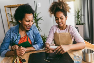 Anne ve kızı birlikte zaman geçirir ve evde kilden heykel yaparlar.