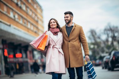 Şehir caddesinde yürüyen ve birlikte alışveriş yapan iki turist. İnsanlar alışveriş eğlence konsepti