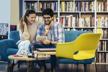 Kafede cep telefonu kullanan genç bir çift..