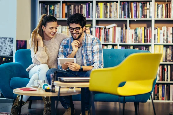 Kafede cep telefonu kullanan genç bir çift..