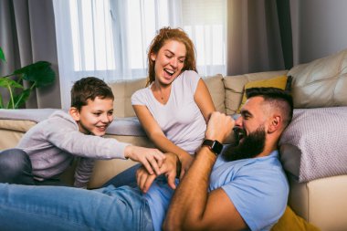 Genç bir aile ve oğulları evde eğleniyorlar.