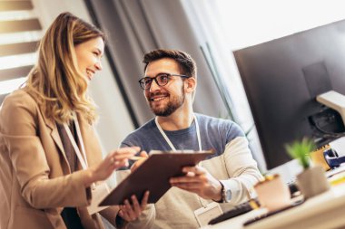 Happy couple doing business together working at small office