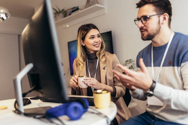 Genç çift evdeki masada otururken bir proje üzerinde çalışıyor.