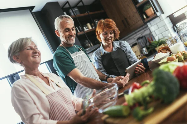 Grupo Amigos Seniores Jantar Casa Cozinhar — Fotografia de Stock
