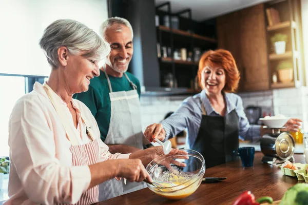 Grupo Amigos Mayores Cena Casa Cocinando —  Fotos de Stock