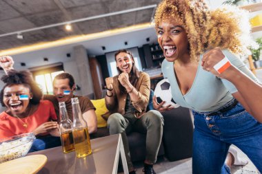 Genç bir grup televizyonda spor izliyor ve tezahürat yapıyor. Duygusal futbol hayranları evde futbol maçı izliyorlar. Boyalı Yüzlü Spor Hayranları TV 'de Kanepe İzleme Oyunu' nda oturuyor