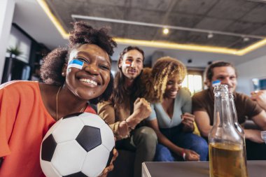 Genç bir grup televizyonda spor izliyor ve tezahürat yapıyor. Duygusal futbol hayranları evde futbol maçı izliyorlar. Boyalı Yüzlü Spor Hayranları TV 'de Kanepe İzleme Oyunu' nda oturuyor