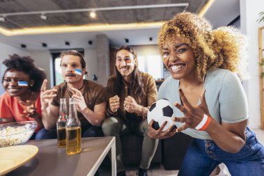 Genç bir grup televizyonda spor izliyor ve tezahürat yapıyor. Duygusal futbol hayranları evde futbol maçı izliyorlar. Boyalı Yüzlü Spor Hayranları TV 'de Kanepe İzleme Oyunu' nda oturuyor