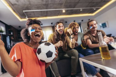 Genç bir grup televizyonda spor izliyor ve tezahürat yapıyor. Duygusal futbol hayranları evde futbol maçı izliyorlar. Boyalı Yüzlü Spor Hayranları TV 'de Kanepe İzleme Oyunu' nda oturuyor