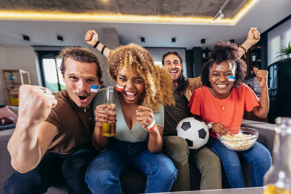 Genç bir grup televizyonda spor izliyor ve tezahürat yapıyor. Duygusal futbol hayranları evde futbol maçı izliyorlar. Boyalı Yüzlü Spor Hayranları TV 'de Kanepe İzleme Oyunu' nda oturuyor