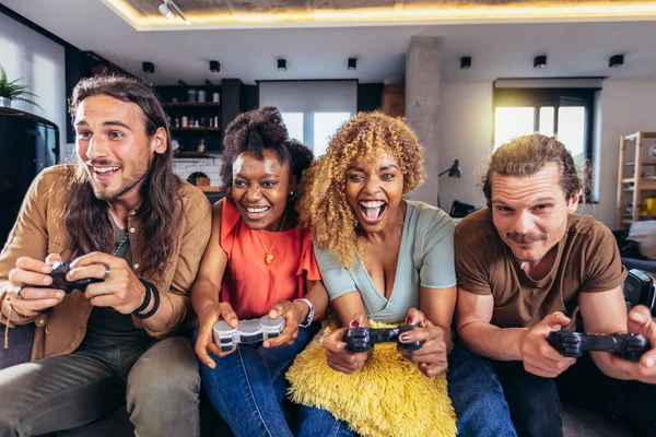 Video oyunu oynayan bir grup arkadaş. Mutlu arkadaşlar evde oyun oynayarak, el kol hareketi yaparak, çığlık atarak, birlikte eğlenerek eğleniyorlar..