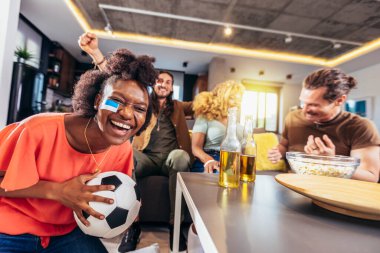 Genç bir grup televizyonda spor izliyor ve tezahürat yapıyor. Duygusal futbol hayranları evde futbol maçı izliyorlar. Boyalı Yüzlü Spor Hayranları TV 'de Kanepe İzleme Oyunu' nda oturuyor