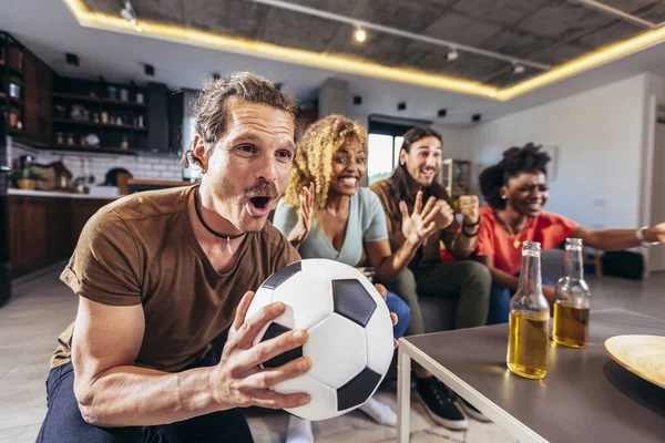 Genç bir grup televizyonda spor izliyor ve tezahürat yapıyor. Duygusal futbol hayranları evde futbol maçı izliyorlar. Boyalı Yüzlü Spor Hayranları TV 'de Kanepe İzleme Oyunu' nda oturuyor