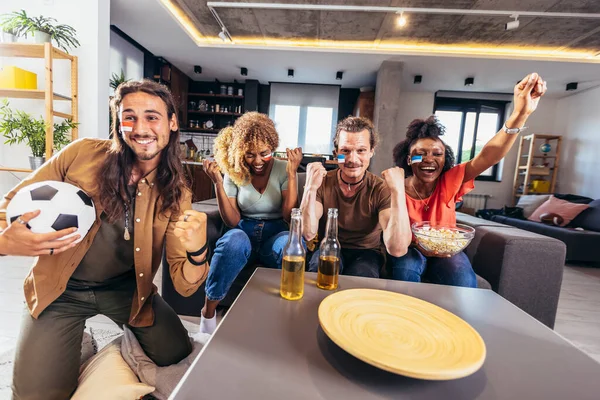 Genç bir grup televizyonda spor izliyor ve tezahürat yapıyor. Duygusal futbol hayranları evde futbol maçı izliyorlar. Boyalı Yüzlü Spor Hayranları TV 'de Kanepe İzleme Oyunu' nda oturuyor