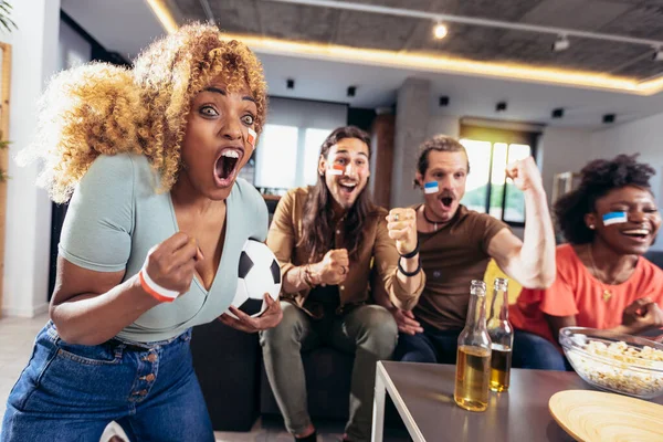 Genç bir grup televizyonda spor izliyor ve tezahürat yapıyor. Duygusal futbol hayranları evde futbol maçı izliyorlar. Boyalı Yüzlü Spor Hayranları TV 'de Kanepe İzleme Oyunu' nda oturuyor