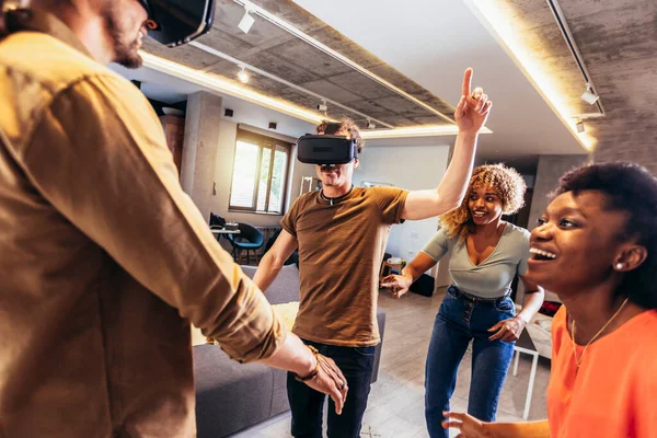 Neşeli arkadaşlar evde VR ile eğleniyorlar.