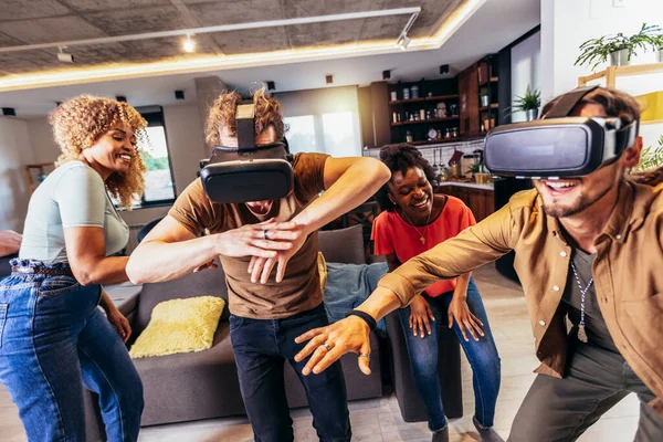 Neşeli arkadaşlar evde VR ile eğleniyorlar.