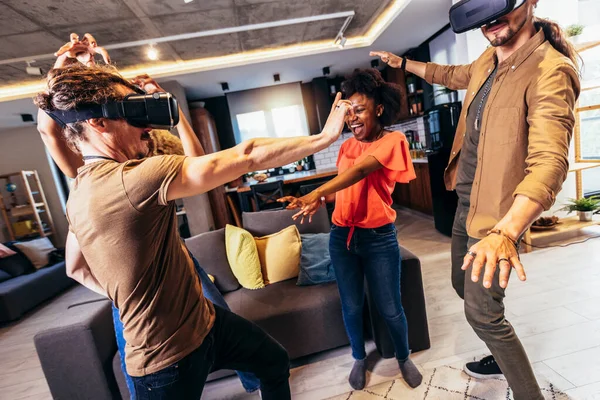 Neşeli arkadaşlar evde VR ile eğleniyorlar.