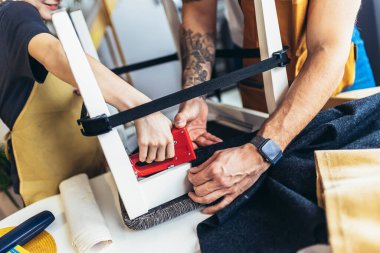 Neşeli genç erkek marangoz ve oğlu atölyede çalışıyor.