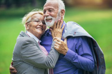 Parkta poz veren güzel yaşlı bir çiftin portresi.