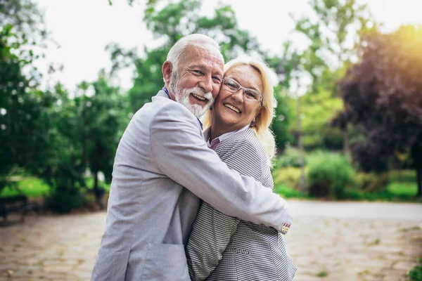 在公园里 年长的 活跃的高加索人夫妻拥抱在一起看起来很快乐 — 图库照片