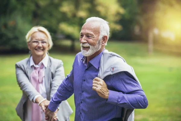 Senior Pareja Caucásica Activa Cogida Mano Feliz Parque Por Tarde —  Fotos de Stock