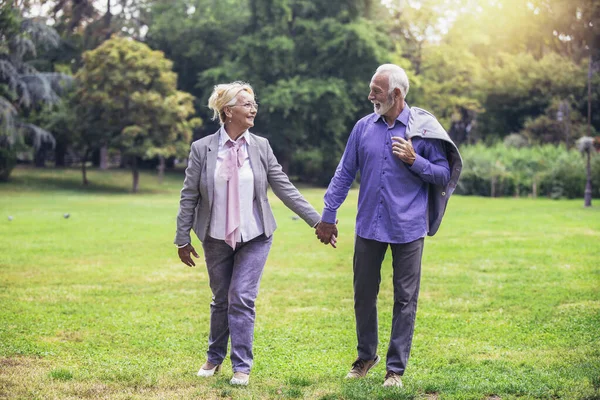 当天下午 年长的活跃的高加索夫妇手牵着手在公园里看起来很开心 — 图库照片