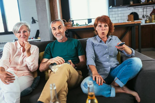 Skupina Seniorů Popcornem Pivem Sledující Spolu Víkendu Doma Televizi — Stock fotografie